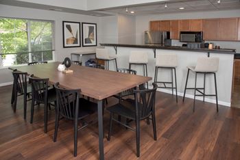 UPI community room with table seating and kitchenat Urban Park I and II Apartments, St Louis Park, 55426